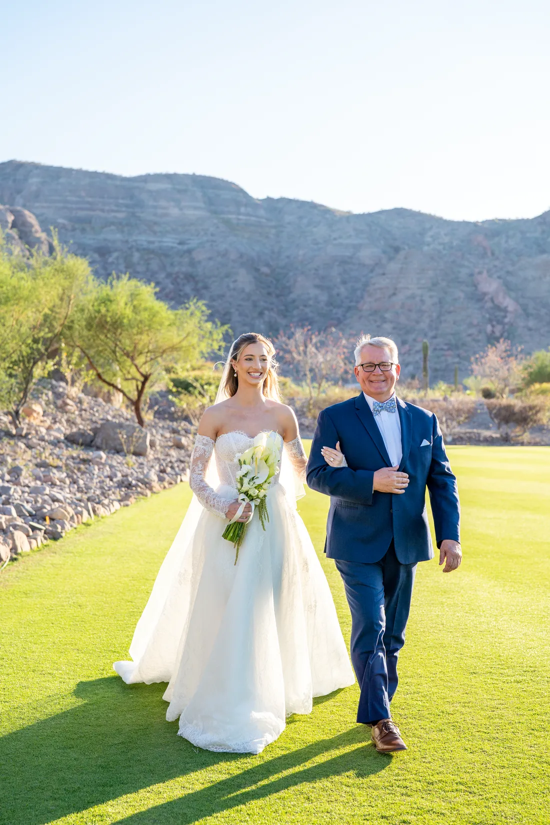 La novia y su papá caminan hacia el altar con la Sierra de la Giganta atrás