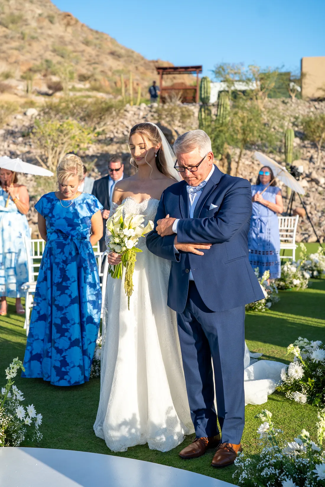 El papá entrega a la novia junto a su mamá, entre los invitados