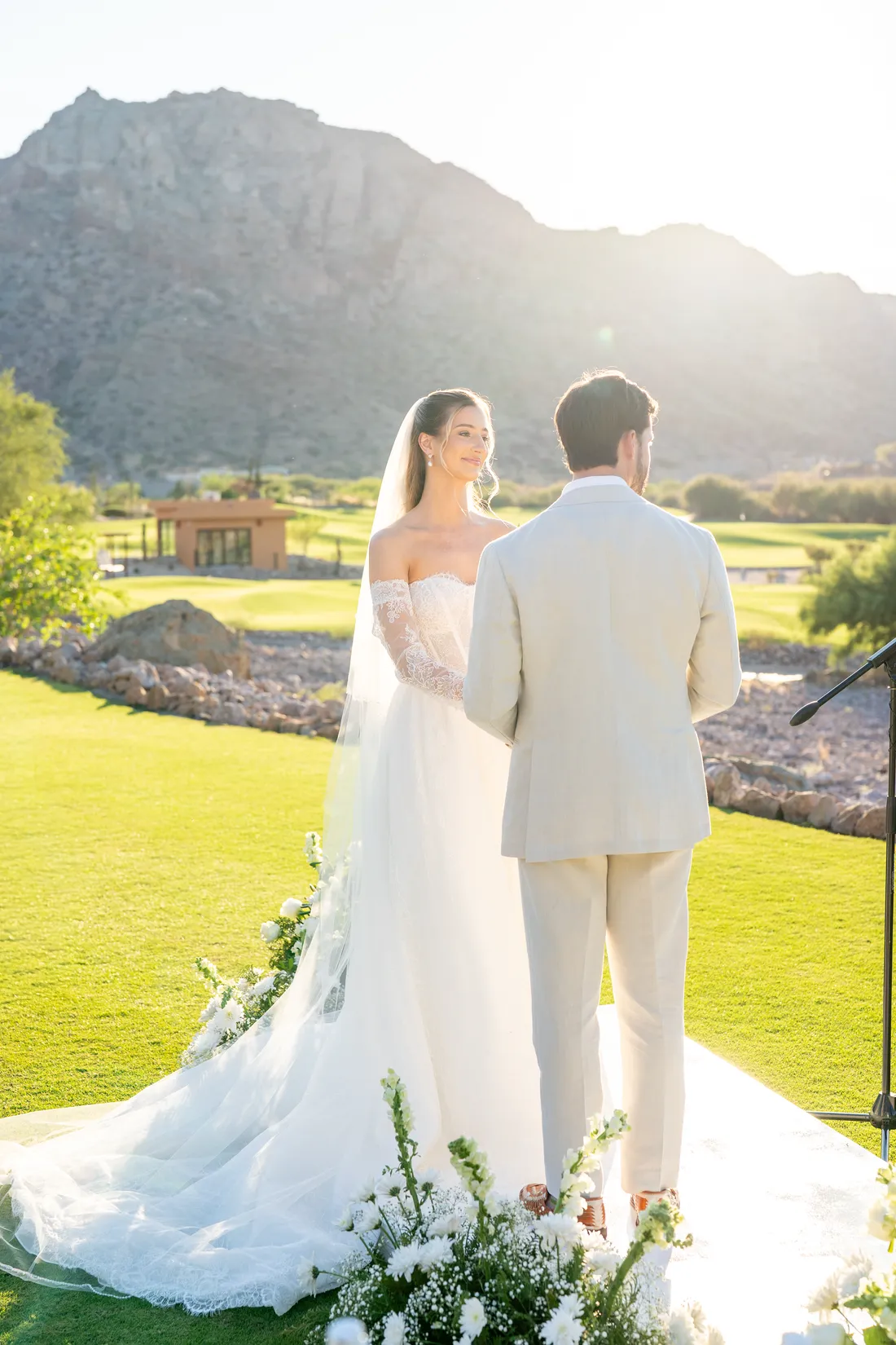 Los novios de espaldas frente al altar, a contraluz del atardecer