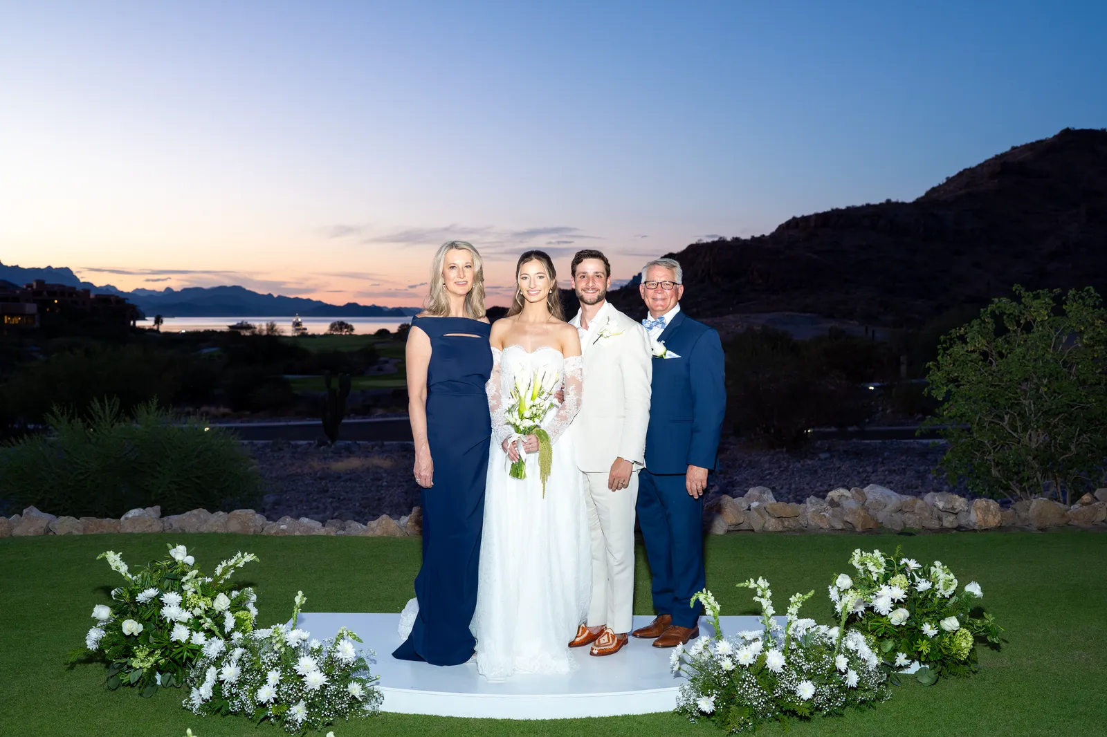 Los novios con la familia frente al atardecer sobre el campo