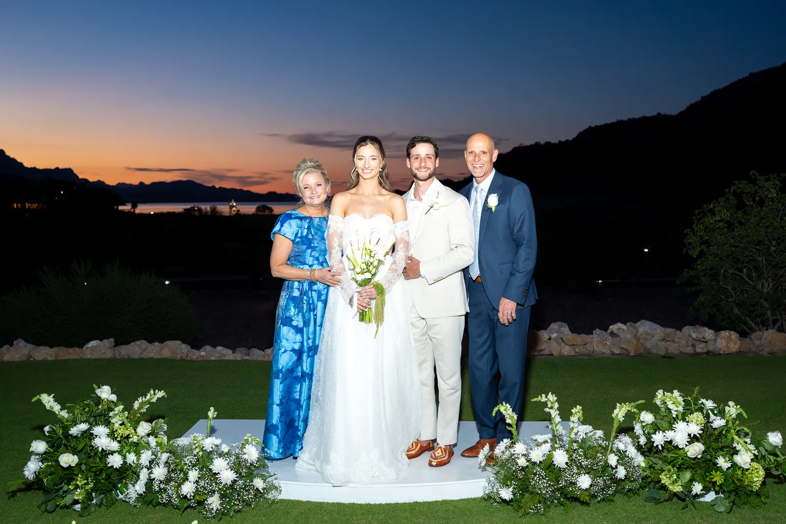 Los novios con los papás de la novia, con el cielo encendido detrás