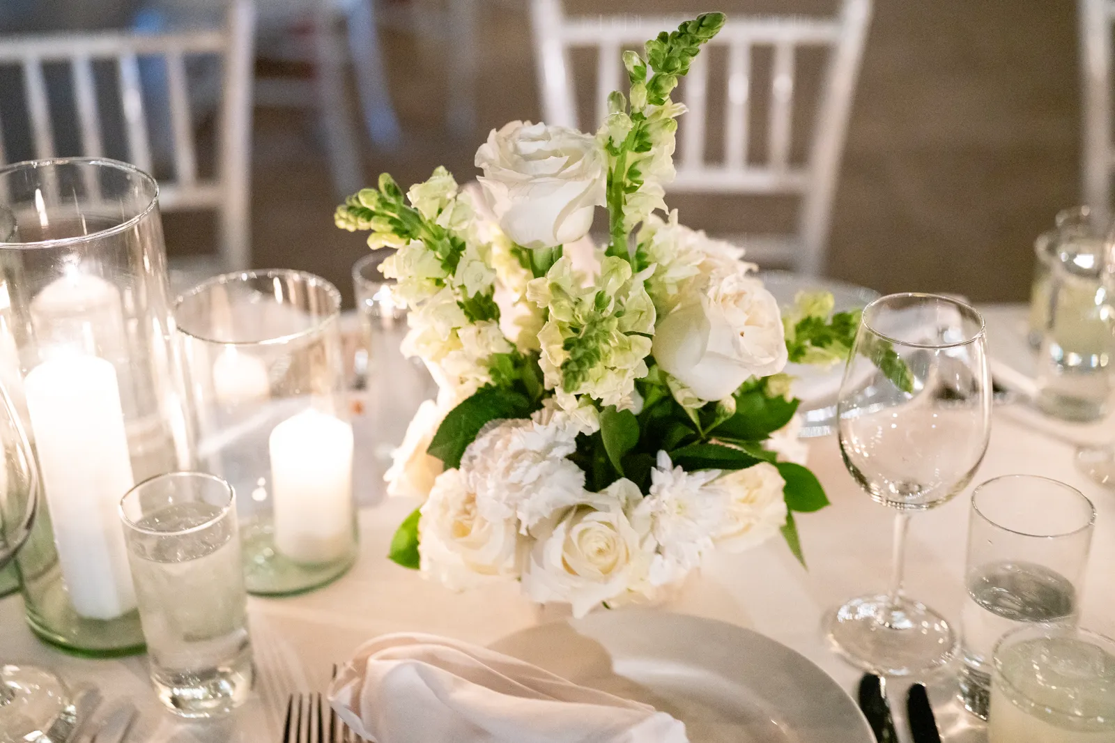 Centro de mesa con velas y flores blancas en la recepción