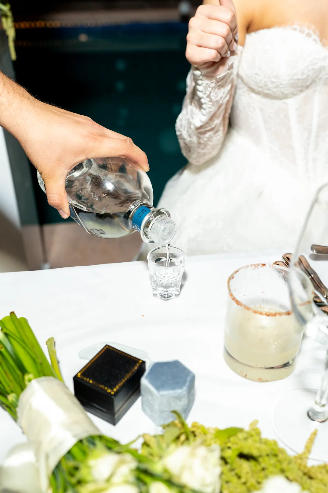 Sirven tequila junto al ramo, en la mesa de los novios