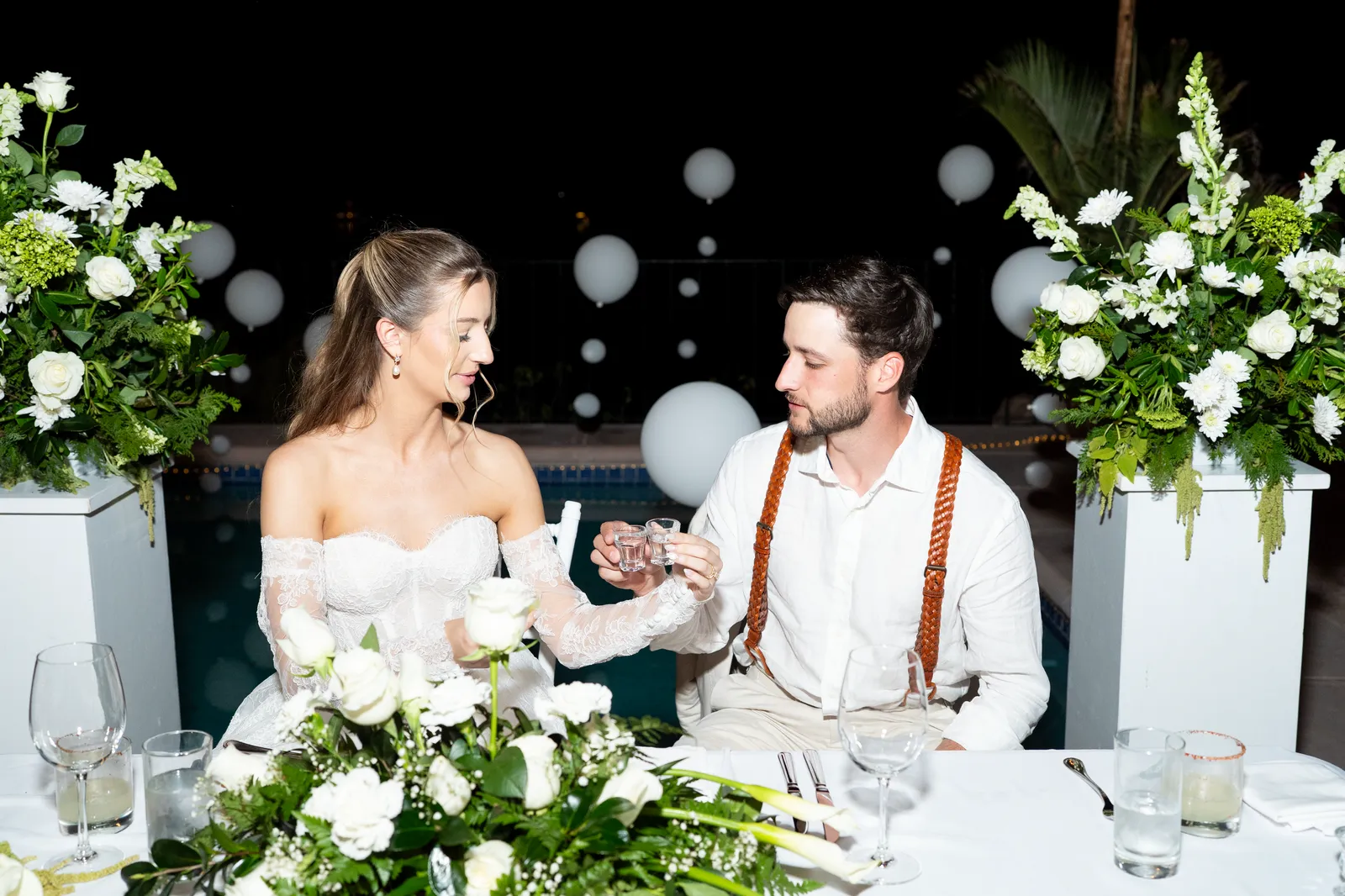 Los novios brindan y ríen en la mesa principal