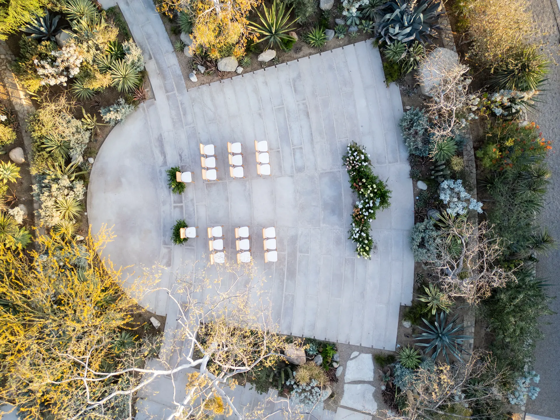 Vista aérea de una ceremonia íntima montada en una terraza rodeada de jardín desértico